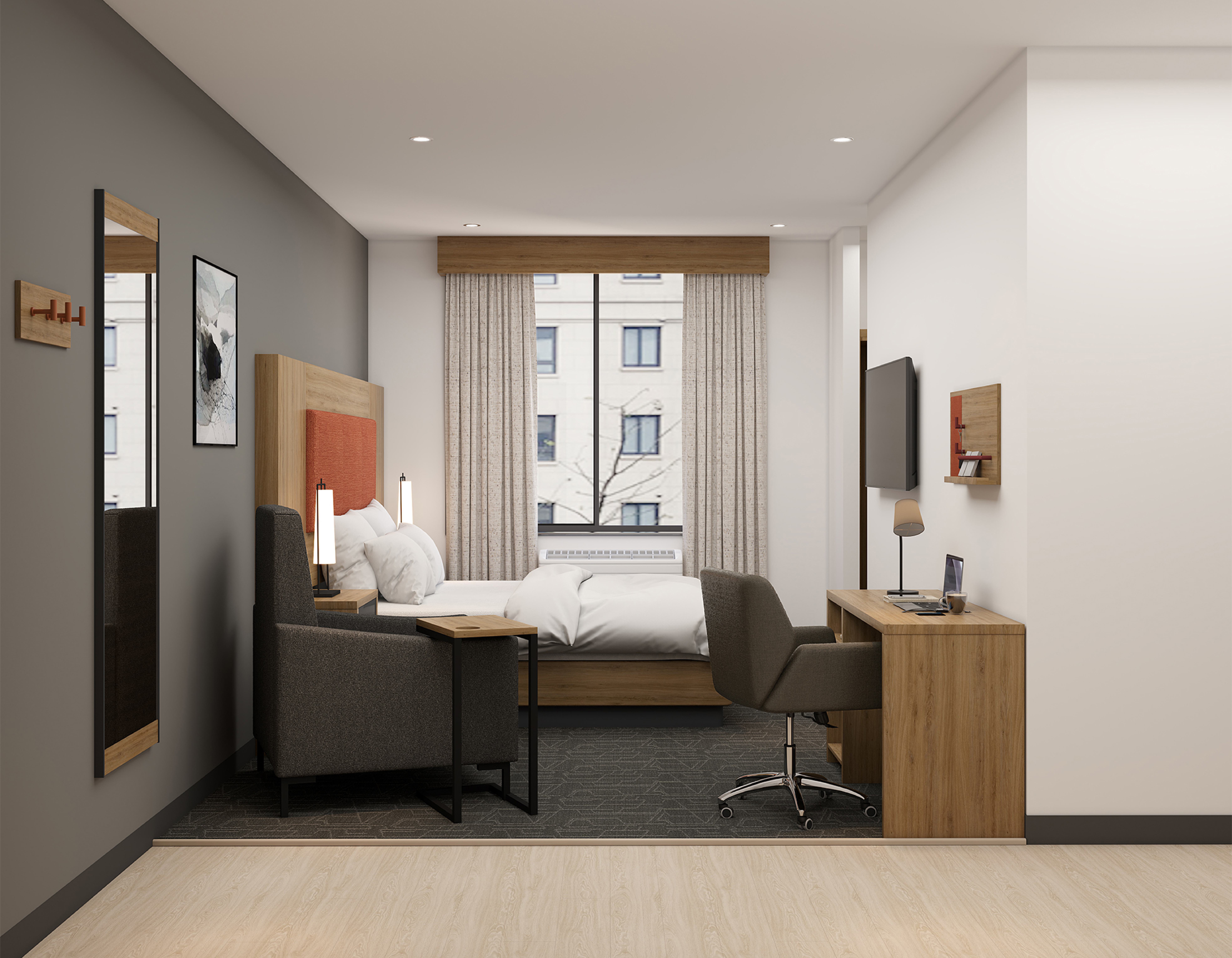 Guest room seating area with lounge chair, desk and wardrobe